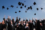 college grads toss caps in the air